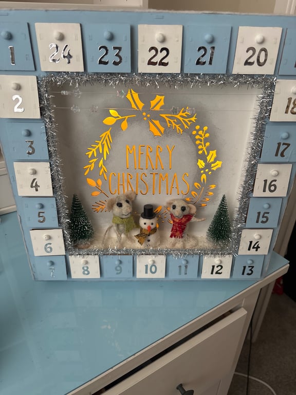 Wooden advent calendar with mice building snowman 