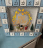 Wooden advent calendar with mice building snowman 