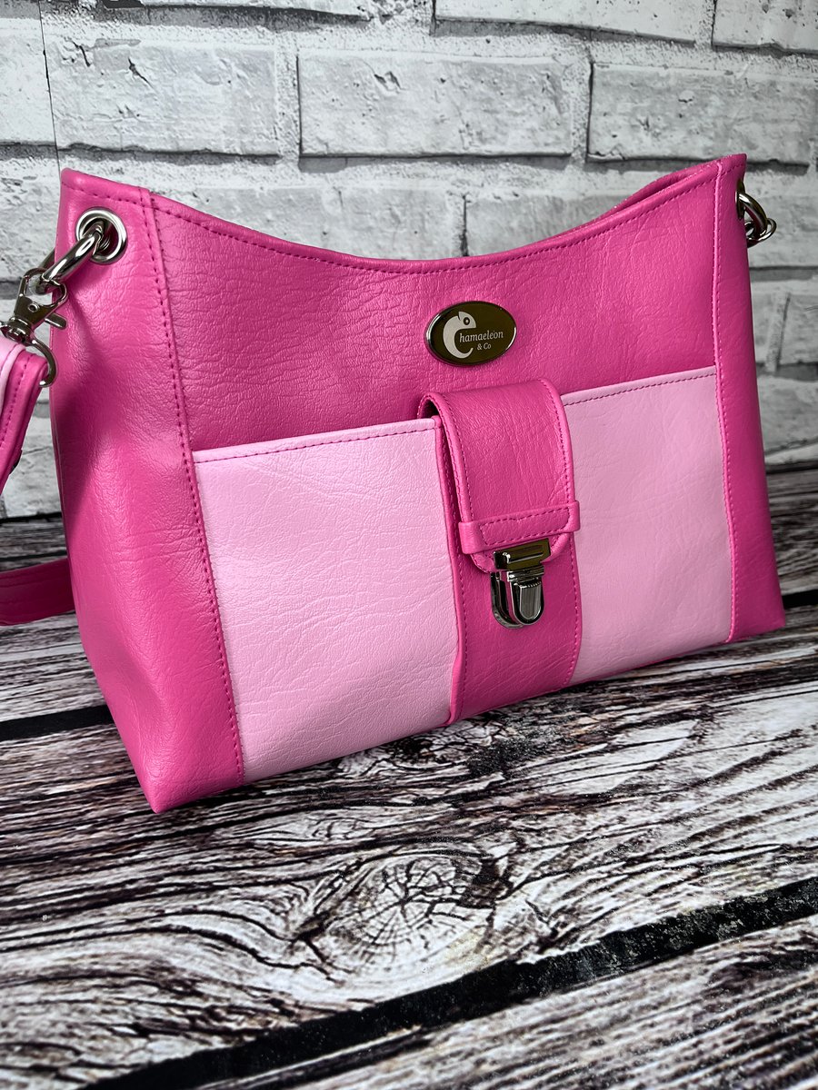 Pink shoulder bag in faux leather with large pale pink front pocket 