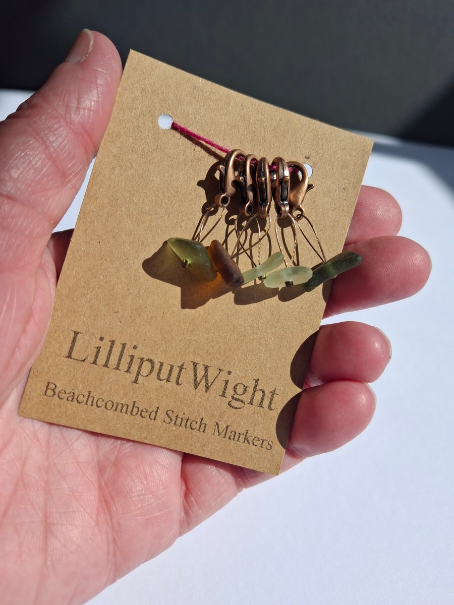 Five sea glass progress keeper stitch markers in shades of green and brown
