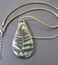 Metallic green and bronze fern tear-drop pendant on a green woven cord. - Image 3