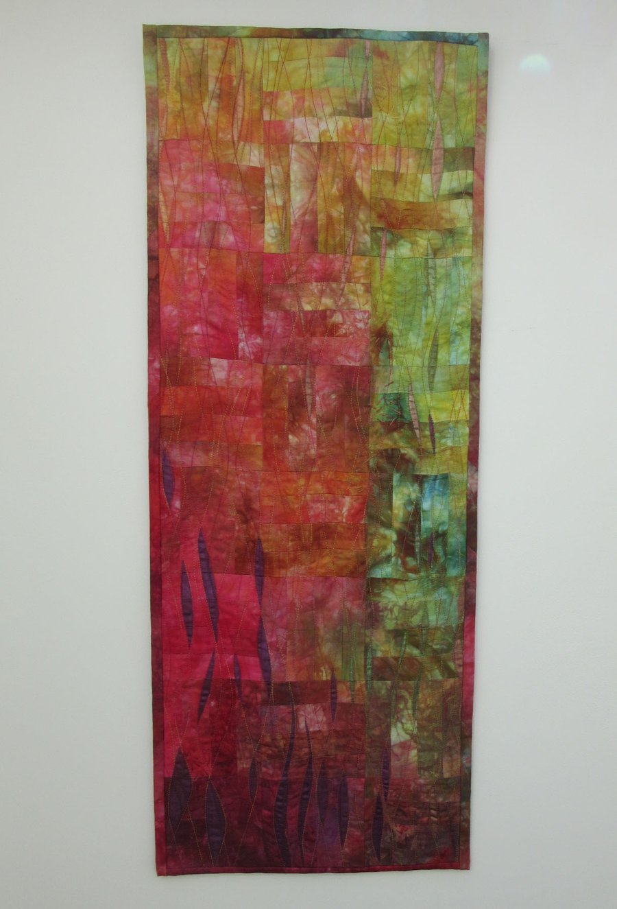 ABSTRACT QUILTED WALL HANGING. A picture of autumn leaves and hedgerows