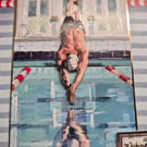 Male swimmer, diving into a swimming pool 