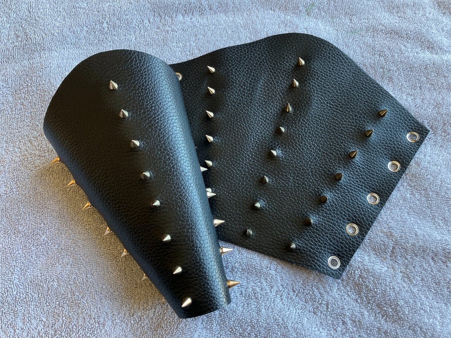 Large pair of black leather bracers with 3 rows of gold coloured spikes