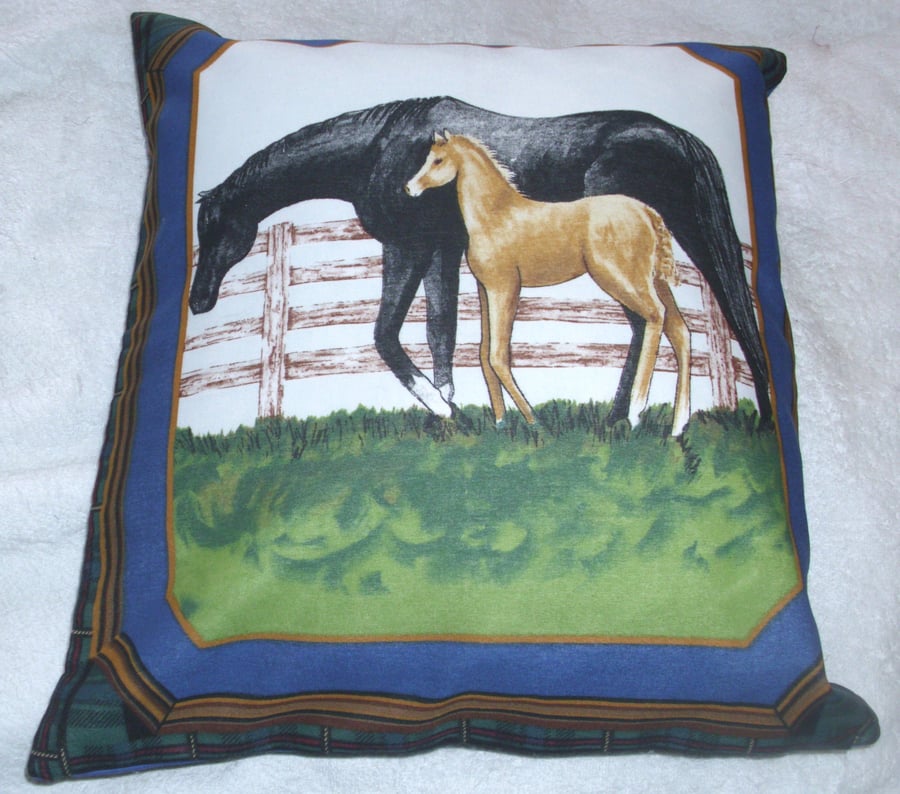 A beautiful black mare and foal by a fence cushion 