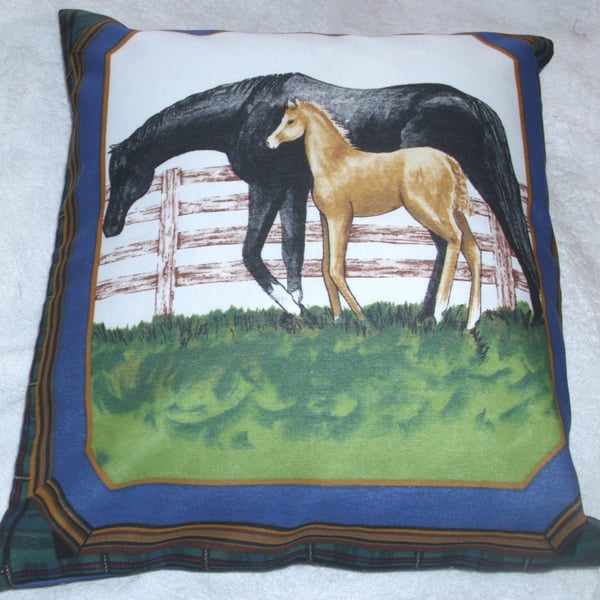 A beautiful black mare and foal by a fence cushion 