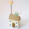 Little wooden house with a clay bird and heart