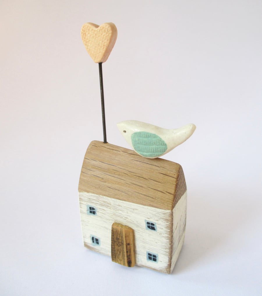 Little wooden house with a clay bird and heart