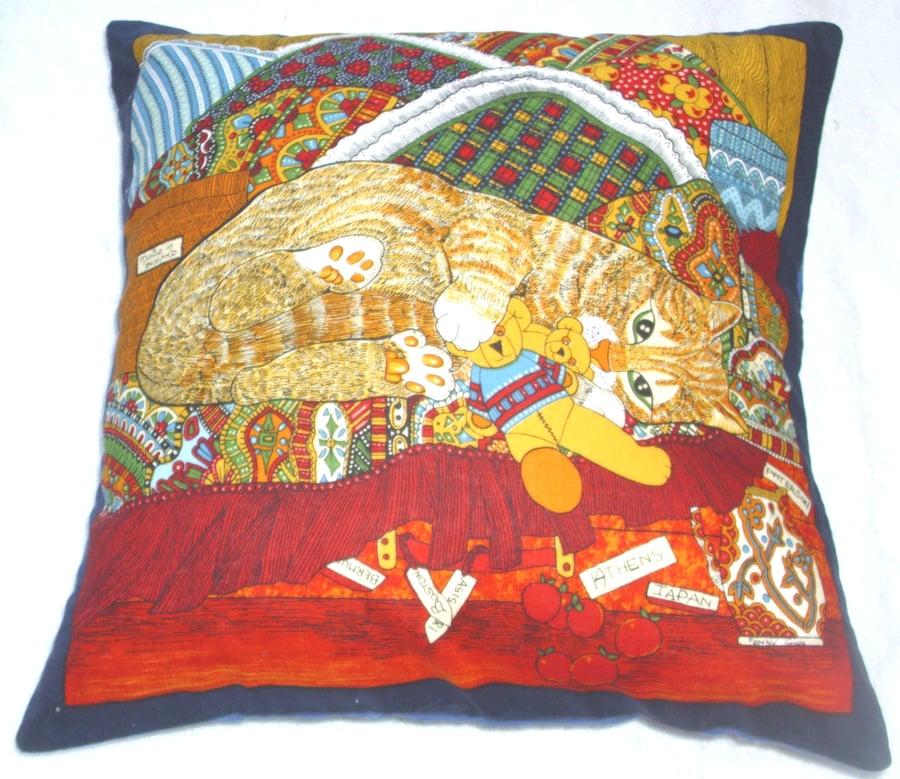 A Ginger tabby kitten among colourful blankets cushion 