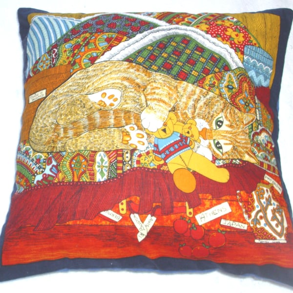 A Ginger tabby kitten among colourful blankets cushion 