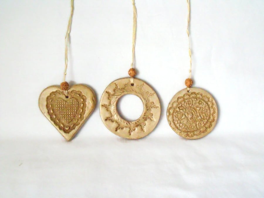 set of three impressed ceramic hanging decorations in beige