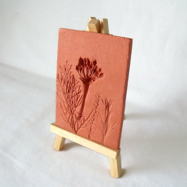 terracotta impressed clay tile displayed on an easel, number 1 of 8 available