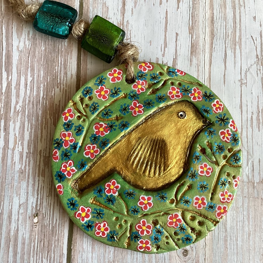 Handmade gold bird hanging decoration, folk art style, nature inspired.