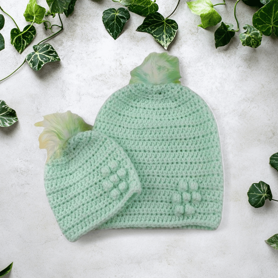 Matching ladies and baby green crocheted hats with detachable faux fur pompoms 