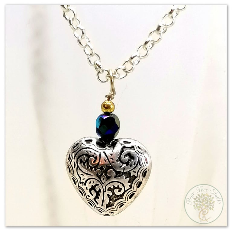 Silver heart necklace with a small black crystal bead on a silver-plated chain.