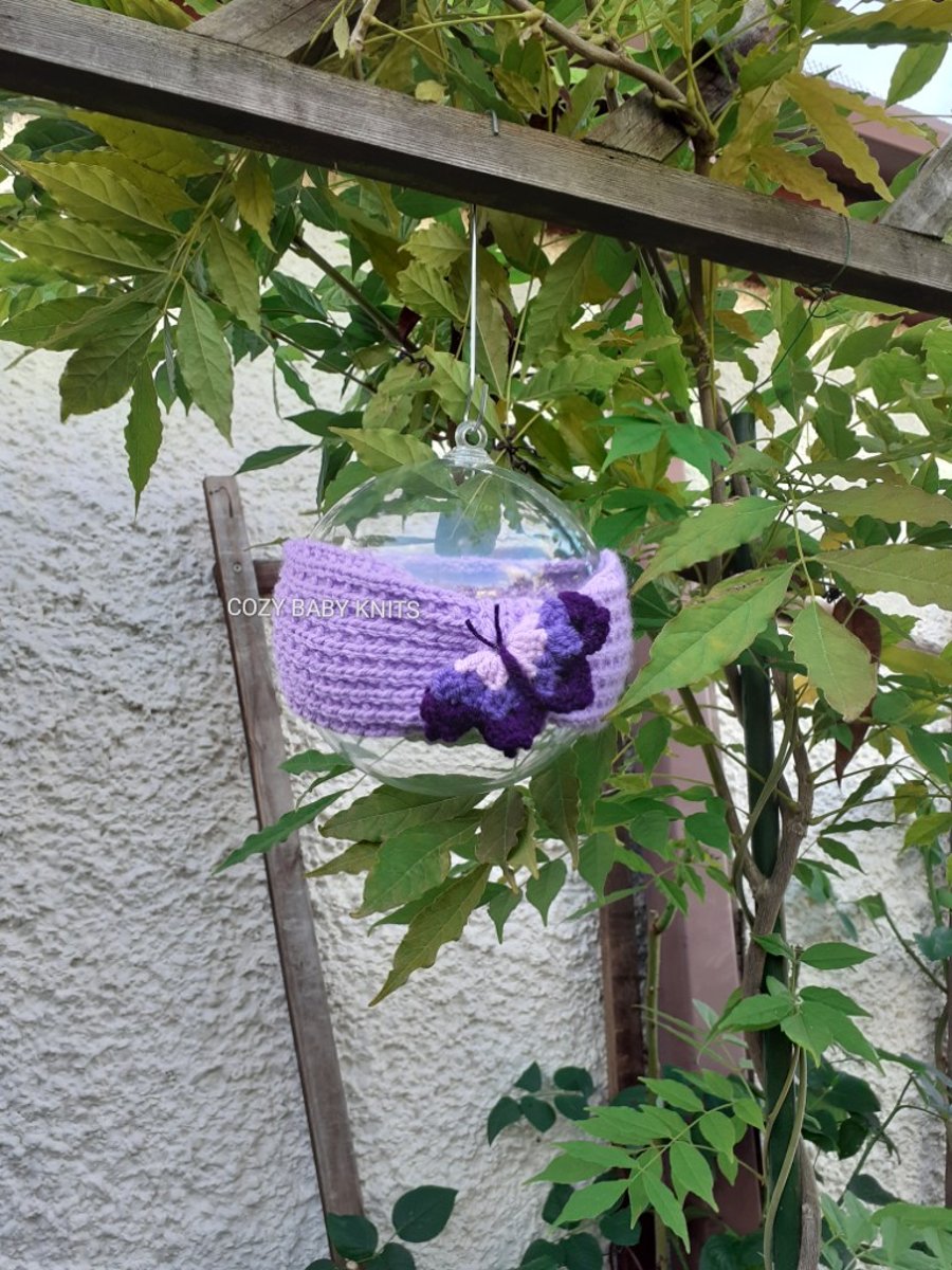  ARAN BABY EARWARMER WITH A BUTTERFLY APPLIQUED ON IT