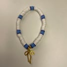 a cute clay bead bracelet with white, a few shades of blue & a golden bow charm!