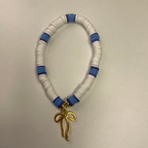 a cute clay bead bracelet with white, a few shades of blue & a golden bow charm!