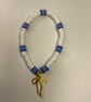 a cute clay bead bracelet with white, a few shades of blue & a golden bow charm!