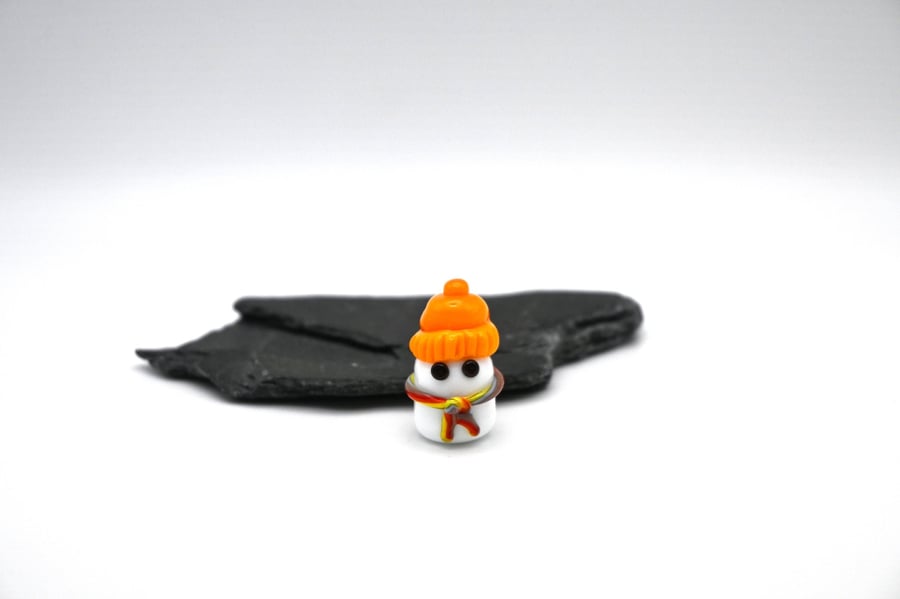 small glass ghost wearing a hat figure