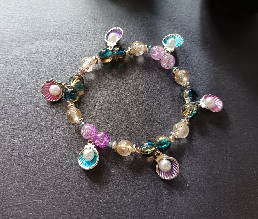 Elasticated bracelet with multicoloured beads and shell and pearl charms 