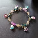 Elasticated bracelet with multicoloured beads and shell and pearl charms 