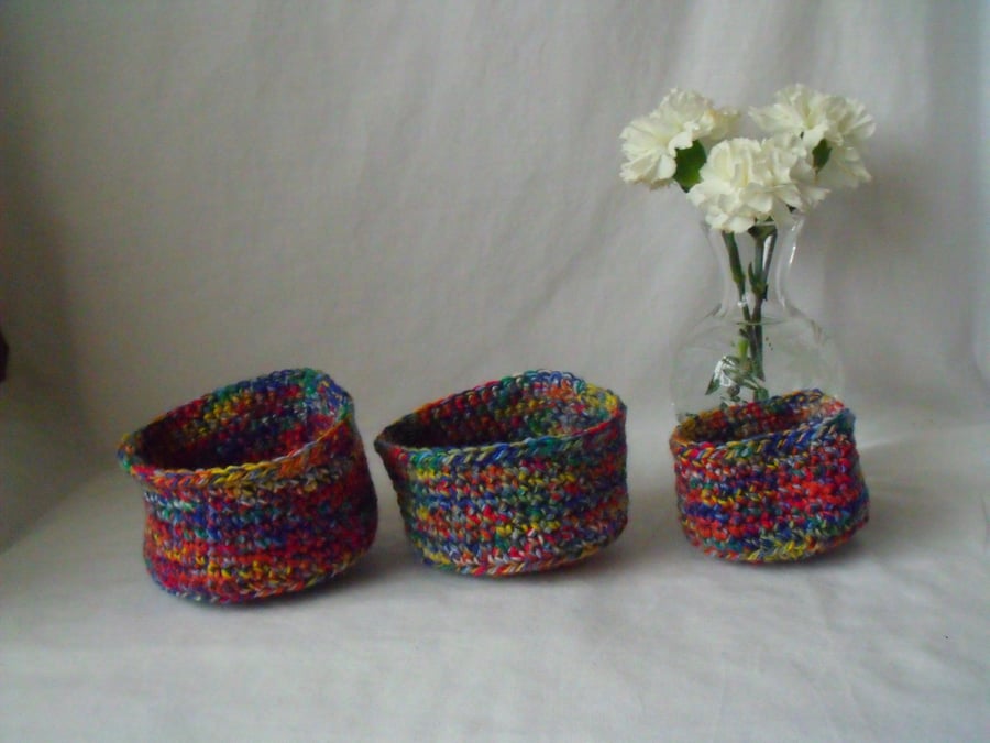set of three multi coloured crocheted stackable craft storage tubs