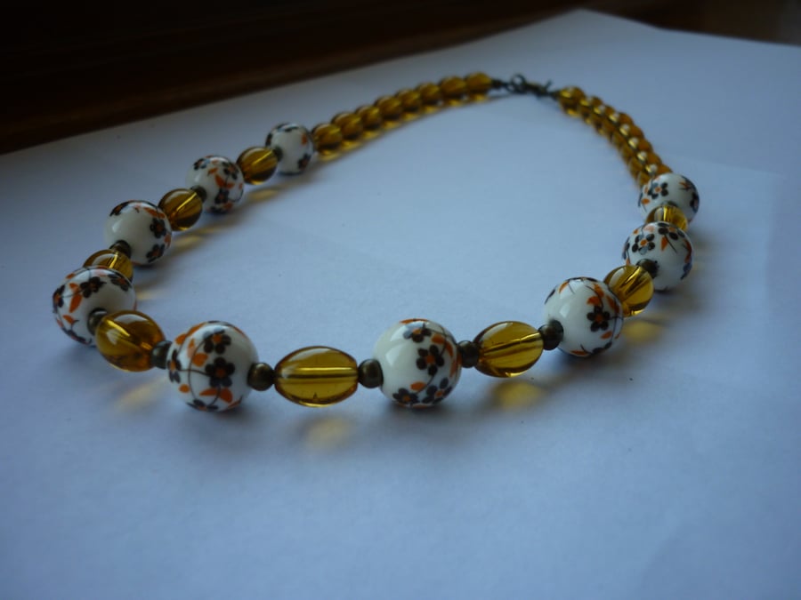 BROWN, WHITE, GOLDEN AMBER AND BRONZE CERAMIC BEAD NECKLACE.  