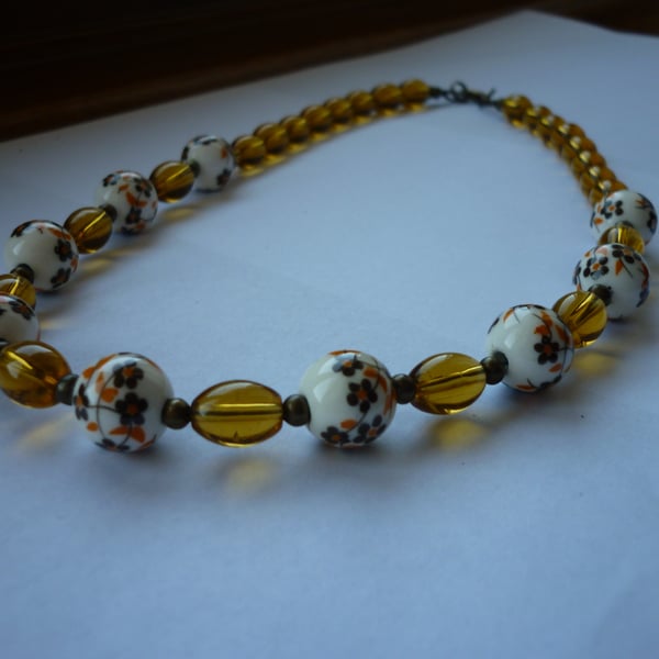 BROWN, WHITE, GOLDEN AMBER AND BRONZE CERAMIC BEAD NECKLACE.  