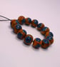 Handmade teal and mustard daisy patterned lamp work glass beads - Image 4