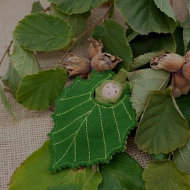 A tiny baby doll in a Hazel leaf