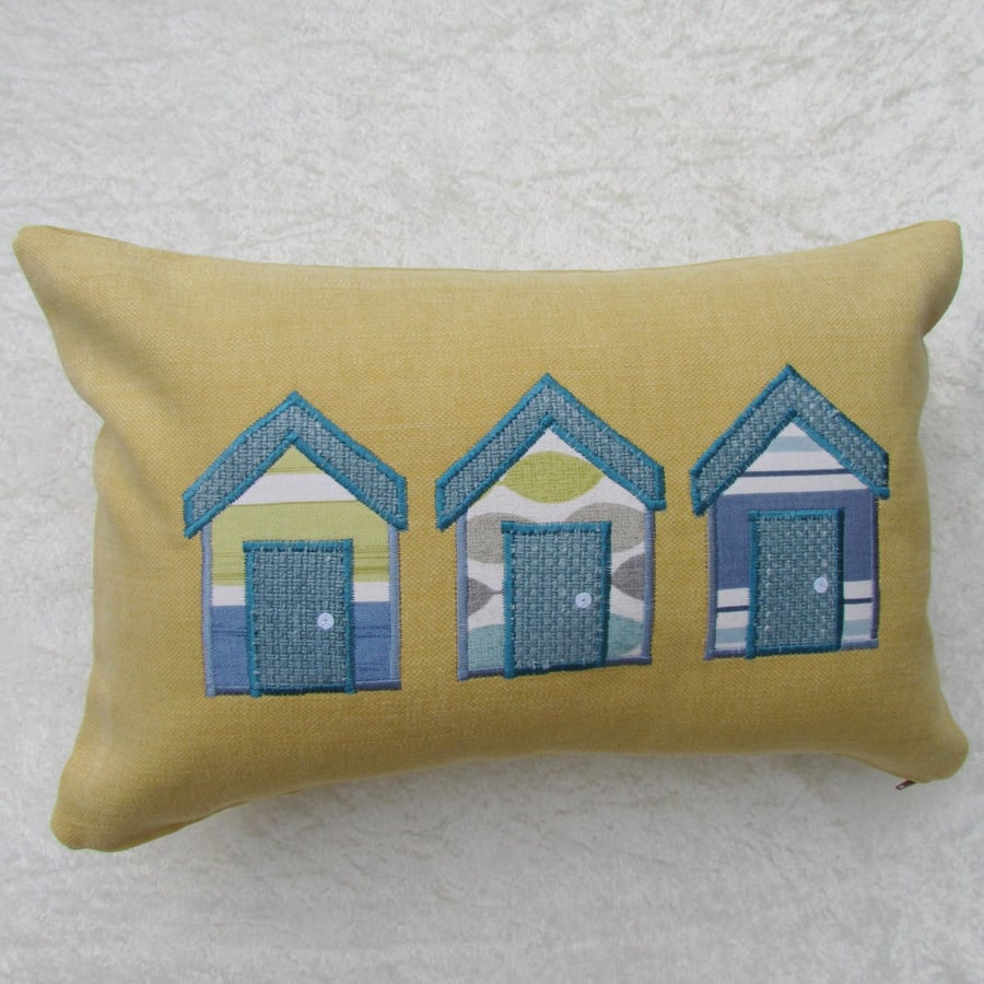Rectangular beach huts cushion in golden yellow with turquoise and blue huts