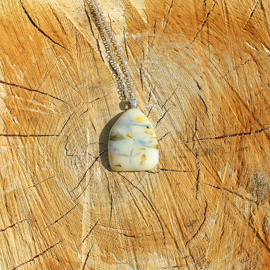 Cream glass pendant on a sterling silver trace chain.
