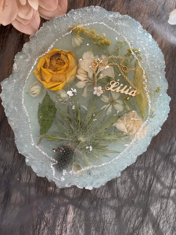 Handmade resin coaster with yellow and white dried flowers and a little of silv 
