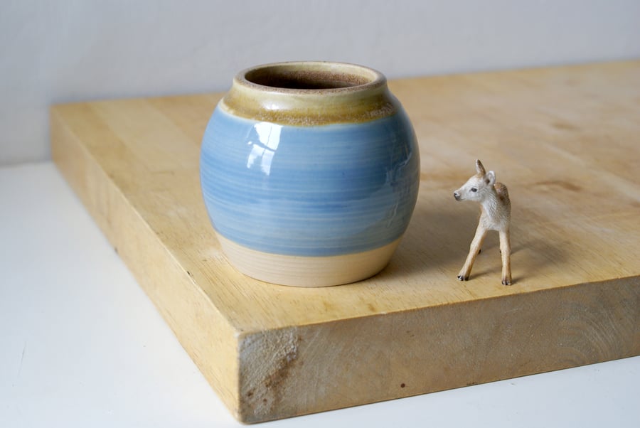 Hand thrown small pottery vase with pale blue band and brown interior