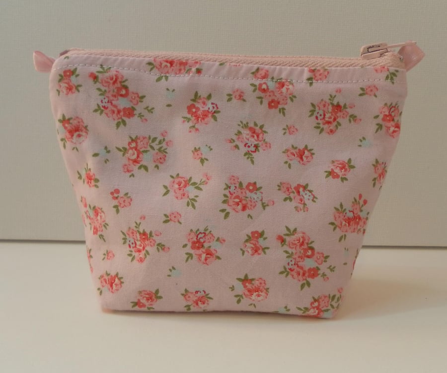 Small make up bag, red and pink roses in clusters on a pink background