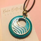 Large teal coloured wood pendant with a wave design