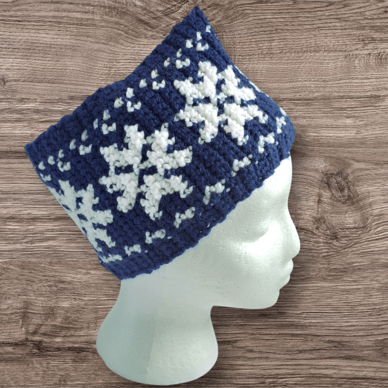 Handcrafted crochet earwarmer with a snowflake design. Blue-white or green-white