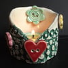 Ceramic tea light holder with heart and flower buttons