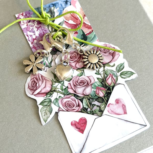 Clip on charms on matt silver card, stitch markers