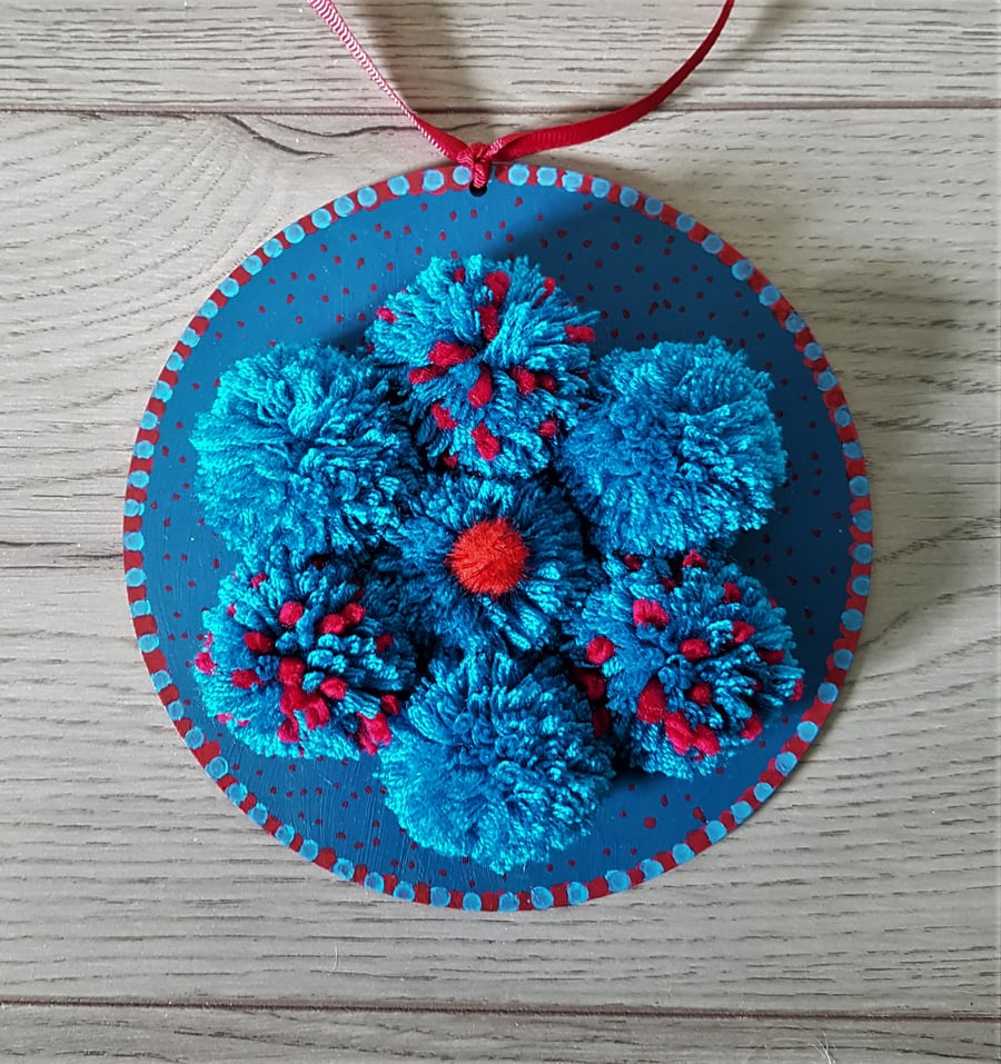 Turquoise and Red pom Pom Flower on wooden plaque 16cms dia