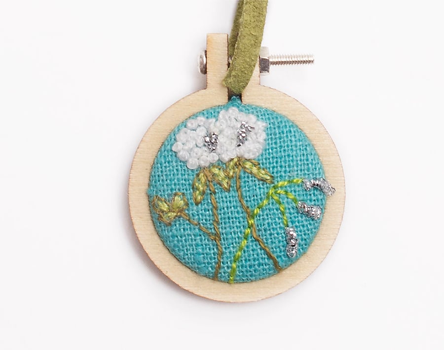 Mini hoop embroidery with hand stitched clover and bluebell on turquoise linen