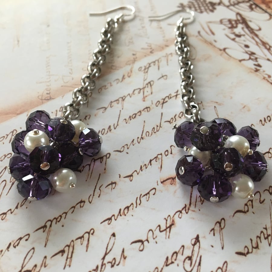 Bunch of purple glass beads with white acrylic pearl dangle earrings.