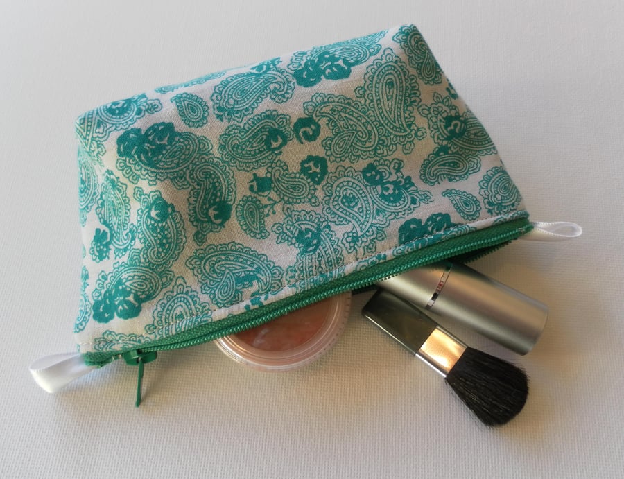 Small make up bag, green paisley pattern on a white background.