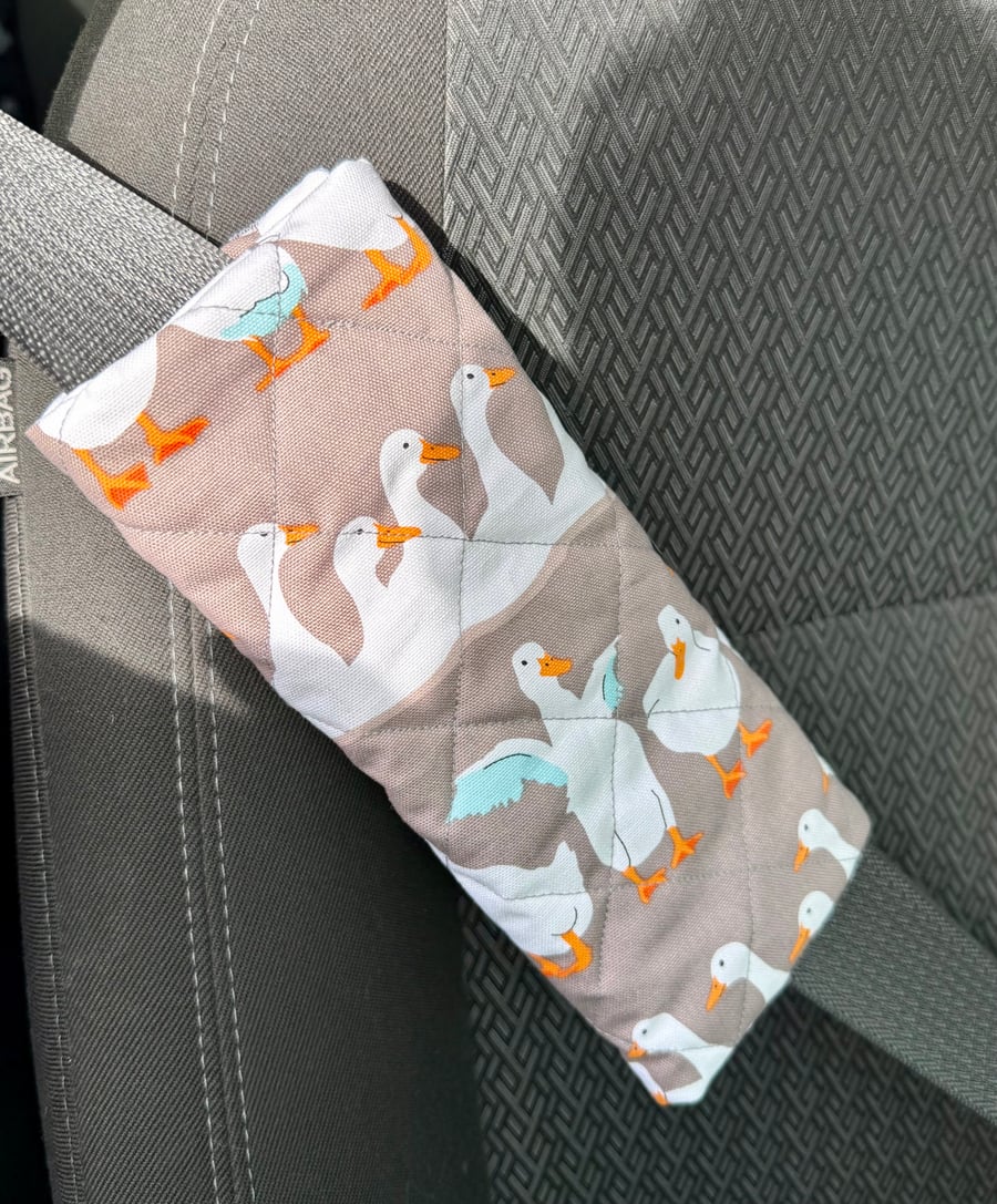 Pair of front seatbelt comfort covers with white runner ducks