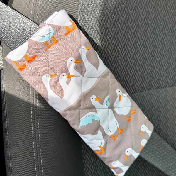 Pair of front seatbelt comfort covers with white runner ducks