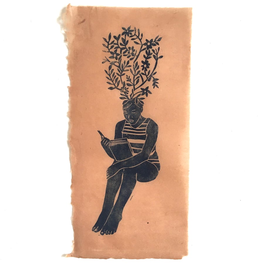 Philomath, linocut print of girl with flowers reading on handmade paper.