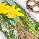 Upcycled embroidered spring rabbit and daffodil home decoration.
