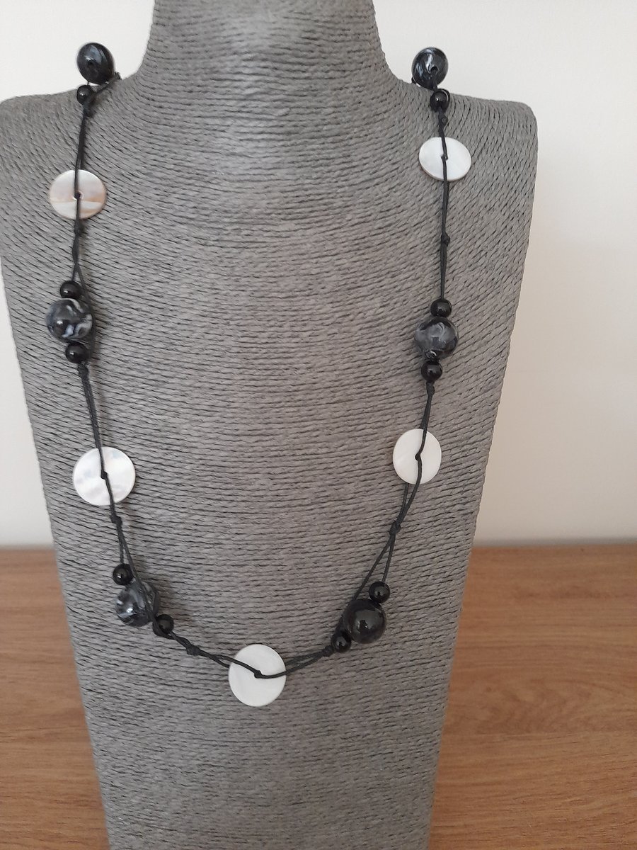 CREAM SHELL AND BLACK BEAD WAXED CORD NECKLACE.