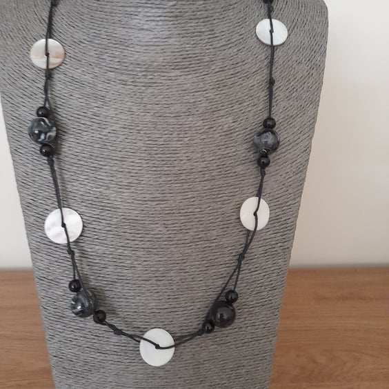 CREAM SHELL AND BLACK BEAD WAXED CORD NECKLACE.